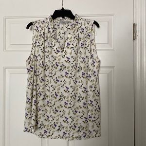 Cream sleeveless blouse with purple and olive print.